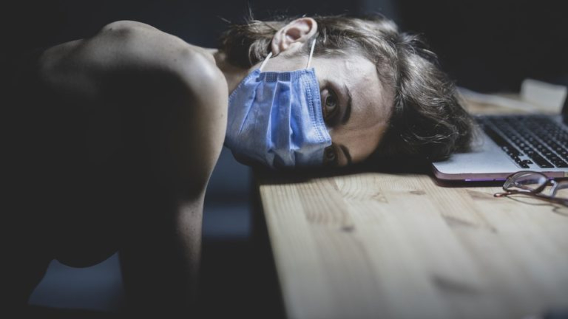 Mujer con mascarilla que refleja el agotamiento laboral y el impacto del burnout en el sector social.