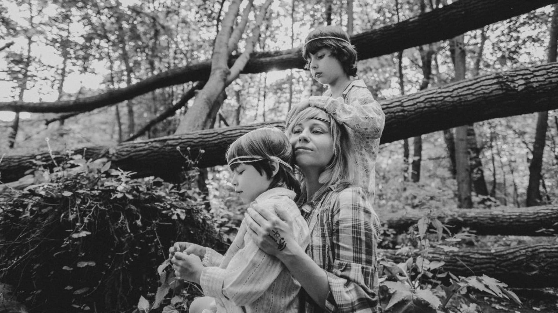 Madre e hijos en la naturaleza, simbolizando el vínculo familiar y la intervención desde una perspectiva feminista.